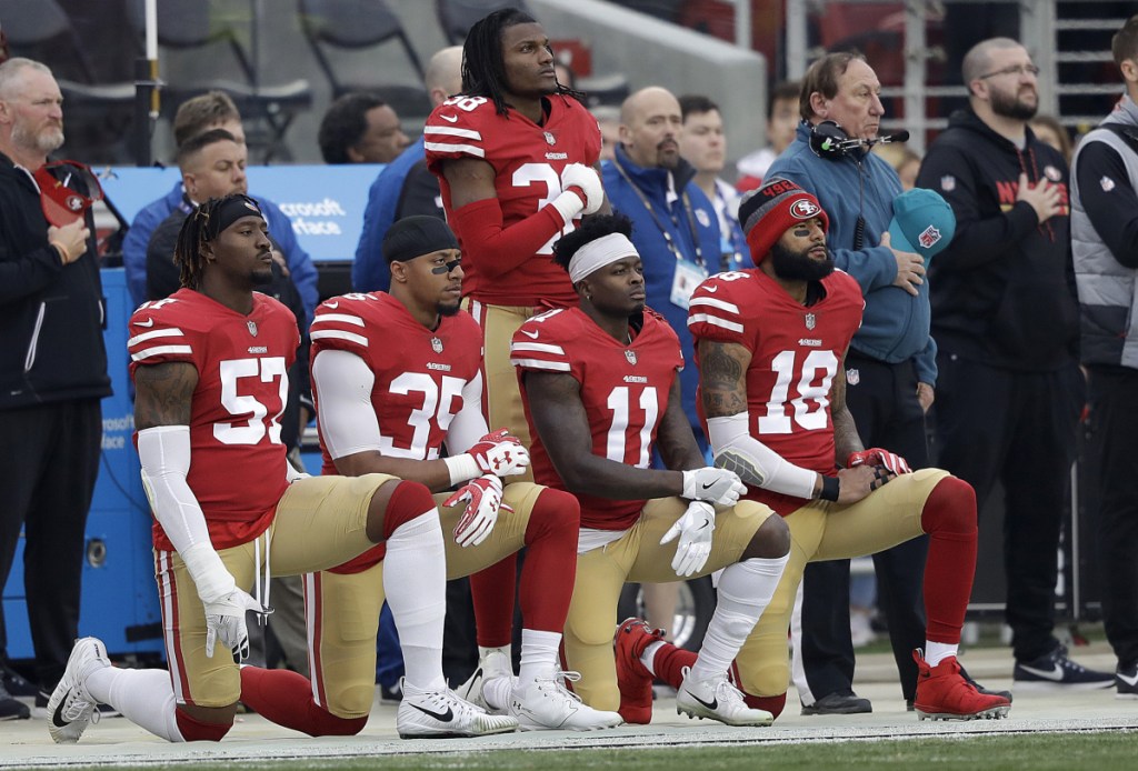 FILE - In this Dec. 24, 2017, file photo, San Francisco 49ers outside linebacker Eli Harold, from bottom left, kneels with safety Eric Reid, wide receiver Marquise Goodwin and wide receiver Louis Murphy during the national anthem before an NFL football game against the Jacksonville Jaguars in Santa Clara, Calif. With the unilateral policy banning players from any on-field protests during the anthem on hold as owners and players discuss the issue, no one can be sure what's ahead. (AP Photo/Marcio Jose Sanchez, File)
