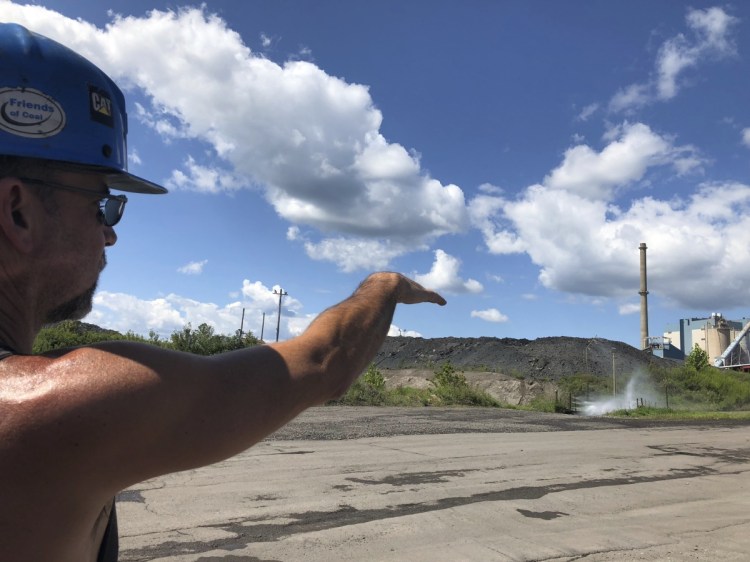 Brian Weekly, a contractor, points out the smokestack of a coal-fired power plant in Grant Town, W.Va. Weekly says coal foes are behind warnings of health risks from emissions.