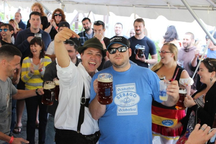 Kai Adams, left, vice president and co-founder of Sebago Brewing, congratulates last year's winner of the Oktoberfest stein-holding contest, Dave Snyder.