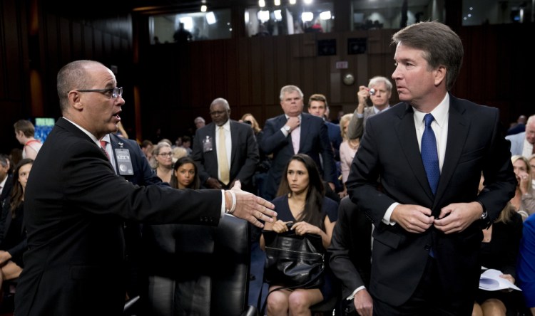 Fred Guttenberg, left, the father of a Parkland school shooting victim, attempts to shake hands with Supreme Court nominee Brett Kavanaugh as the Senate Judiciary Committee breaks for lunch Tuesday.