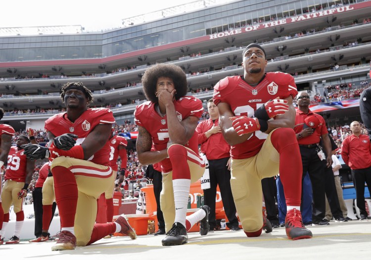 From left, San Francisco 49ers outside linebacker Eli Harold, then-quarterback Colin Kaepernick and safety Eric Reid kneel during the national anthem before a game against the Dallas Cowboys on Oct. 2, 2016. Most of the athletes who have participated in the ongoing protest have not only taken a knee but also donated money and time to solving problems in their own communities.