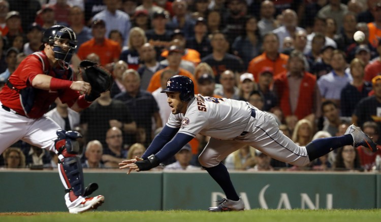 Houston's George Springer goes for a headfirst slide into home as Red Sox catcher Sandy Leon gets a late throw during the eighth inning Friday night at Fenway Park.
