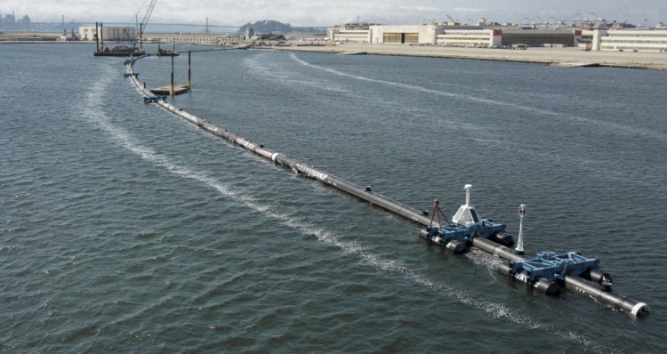 A long floating boom that will be used to corral plastic litter in the Pacific Ocean is assembled in Alameda, Calif. Engineers will deploy the device between California and Hawaii in an attempt to trap some of the 1.8 trillion pieces of plastic from The Great Pacific Garbage Patch.