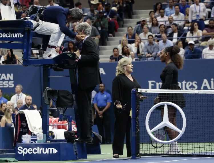 Chair umpire Carlos Ramos, left, talks with referee Brian Earley as Serena Williams talks with Donna Kelso during the women's final of the U.S. Open against Naomi Osaka on Saturday in New York.