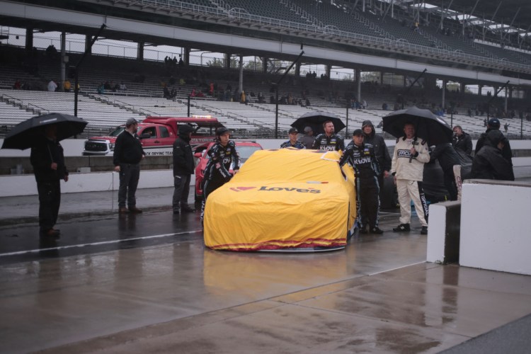 The team of NASCAR Cup Series driver Michael McDowell push his car to the garage area during a rain delay before the Brickyard 400 at Indianapolis Motor Speedway in Indianapolis, Sunday. The race was postponed until Monday.