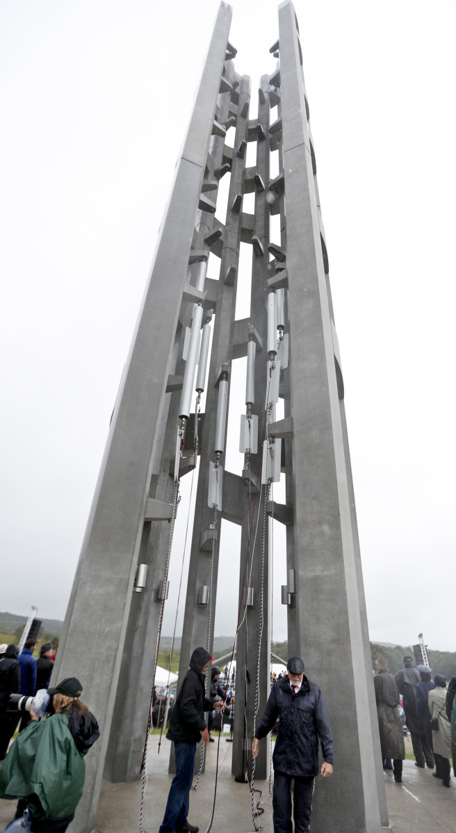 Members of the families of passengers of Flight 93 join others under the 93-foot tall Tower of Voices after it was dedicated on Sunday in Shanksville, Pa. The tower contains 40 wind chimes representing the 40 people who perished in the crash of Flight 93 in the terrorist attacks of Sept. 11, 2001.