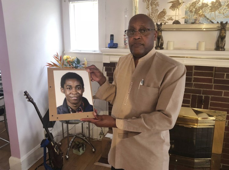 Dia Khafra, father of Askia Khafra, holds a photo of his son in his Silver Springs, Md., home. Askia Khafra died last year when a fire broke out at the Bethesda, Md., home where he and a millionaire day trader were digging tunnels for a nuclear bunker.
