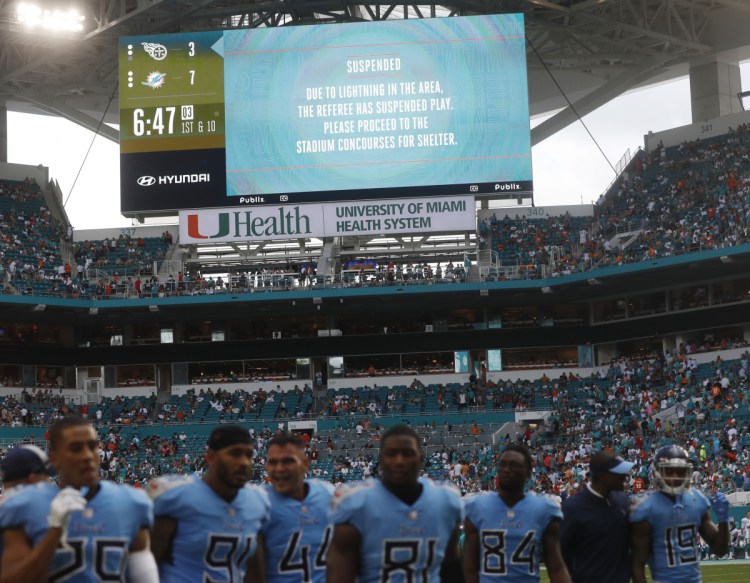 Tennessee Titans players leave the field after a second lightning delay was called during the second half of their game against the Dolphins on Sunday in Miami Gardens, Florida.