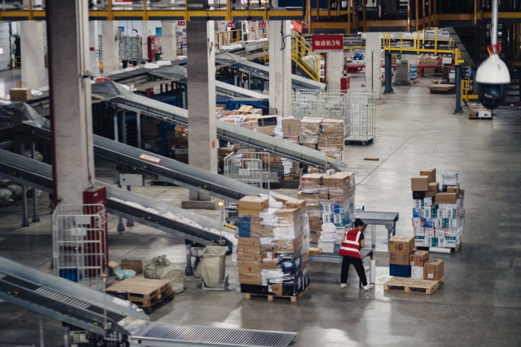 A member of JD.com's staff works, nearly alone, in the company's sprawling warehouse near Shanghai. "I don't get lonely," says one of the four human workers staffing the place, "because of the robots."