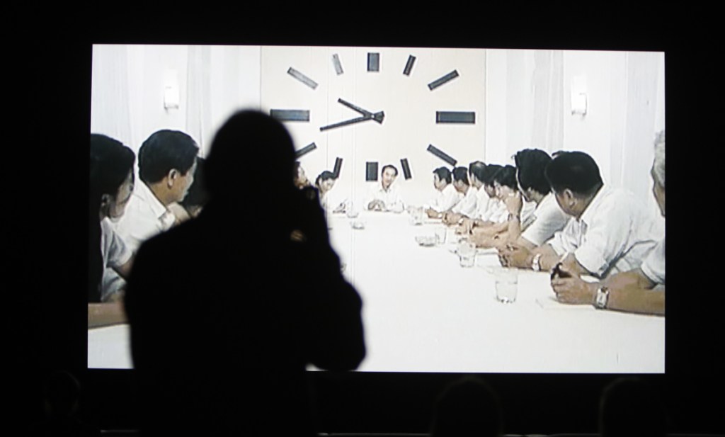 People watch a section of the 24 hour video installation called "The Clock" at the Tate Modern in London.
