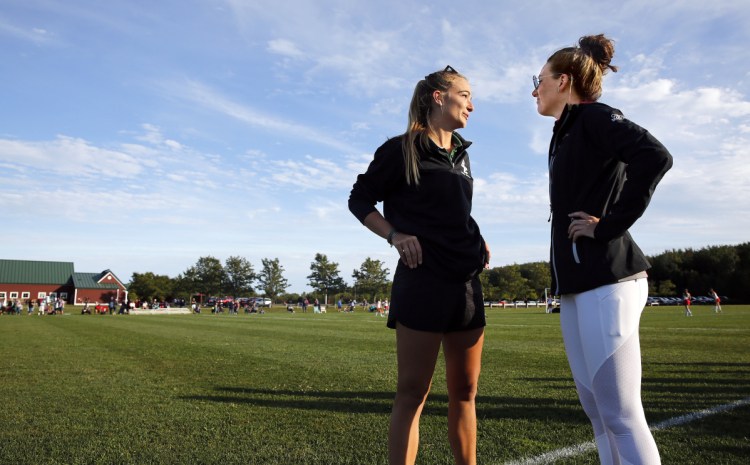 Field hockey coaches Vonde Saunders, left, of Bonny Eagle and Olivia Madore of South Portland chat after their teams played each other last Friday. A year ago, Saunders and Madore were senior teammates on the University of New England's field hockey team.