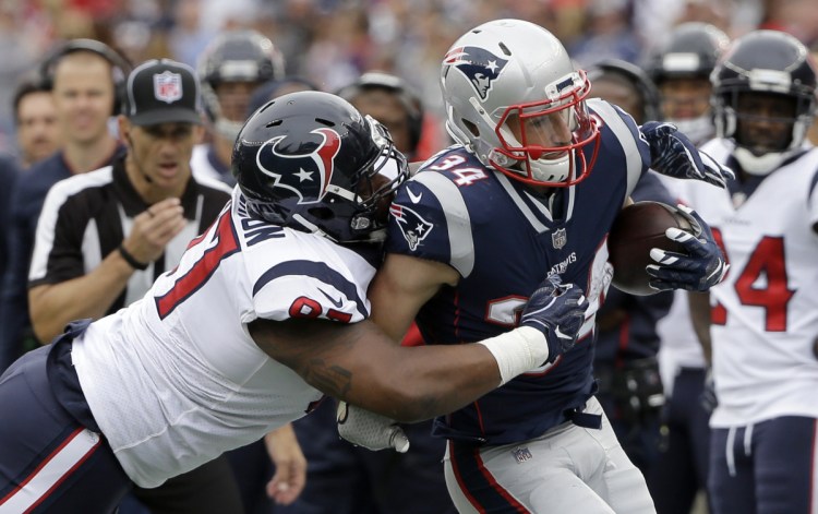 New England running back Rex Burkhead tries to get away from Houston defensive end Angelo Blackson during Sunday's game. Burkhead, on Wednesday's injury report with a concussion, rushed for 64 yards on 18 carries against the Texans.