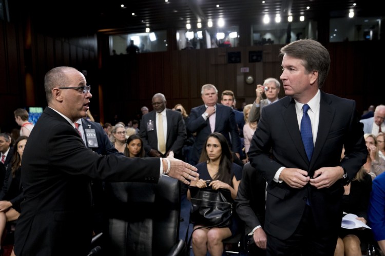 Fred Guttenberg, the father of Jamie Guttenberg who was killed in the Stoneman Douglas High School shooting in Parkland, Fla., left, attempts to shake hands with President Donald Trump's Supreme Court nominee, Brett Kavanaugh, right, as he leaves for a lunch break while appearing before the Senate Judiciary Committee on Sept. 4.