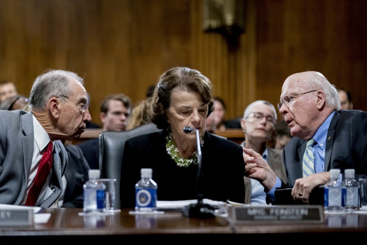 Senate Judiciary Committee Chairman Chuck Grassley, R-Iowa, left, accompanied by Sen. Dianne Feinstein, D-Calif., the ranking member, center, speaks with Sen. Patrick Leahy, D-Vt., right, during a Senate Judiciary Committee markup meeting on Capitol Hill on Thursday in Washington. The committee will vote next week on whether to recommend President Trump's Supreme Court nominee, Brett Kavanaugh for confirmation. Republicans hope to confirm him to the court by Oct. 1.