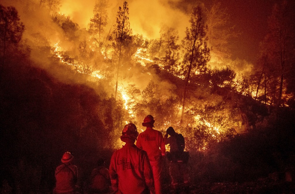 Firefighters monitor a backfire while battling the Ranch Fire near Ladoga, Calif., in August. California is leading the way in fighting climate change, passing a law to make the state's electrical grid carbon free by 2045. As human-caused climate change has warmed the world, forest fires have become a serious problem.
Associated Press/Noah Berger