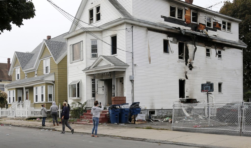 Lawrence residents stop to take photos of a house on Bowdoin Street in Lawrence Mass., Friday, Sept. 14, 2018. The home was one of multiple houses that went up in flames on Thursday afternoon after gas explosions and fires triggered by a problem with a gas line that feeds homes in several communities north of Boston (AP Photo/Mary Schwalm)