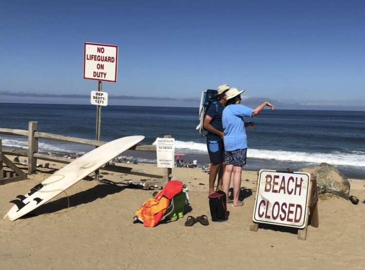 Two people look out from the shore after a shark attack at Newcomb Hollow Beach in Wellfleet, Mass, on Saturday.