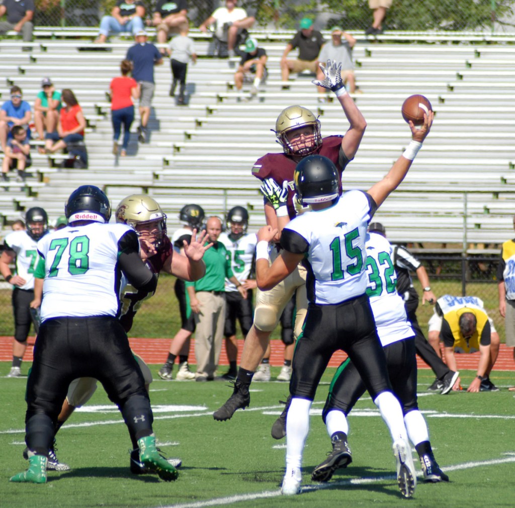 Thornton Academy's Ethan Logan tries to knock down a pass from Nick Roberge of Massabesic during Thornton Academy's 63-7 win Saturday in Saco.