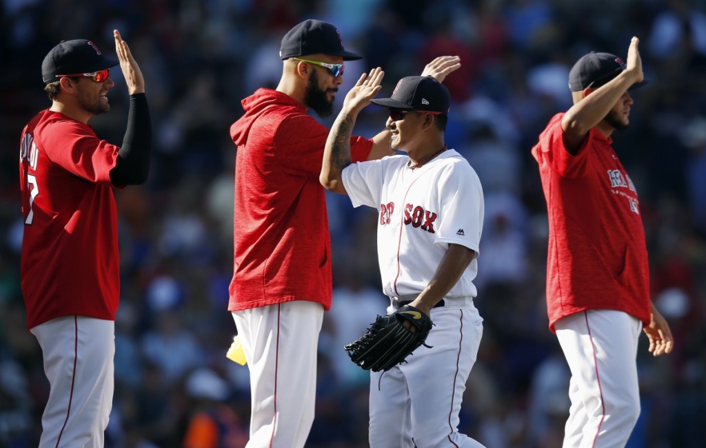 Boston's Tzu-Wei Lin, right, celebrates with pitchers Nathan Eovaldi and David Price after Sunday's win over the Mets. Boston can wrap up the AL East with one win during a three-game series this week visiting that other New York team.
