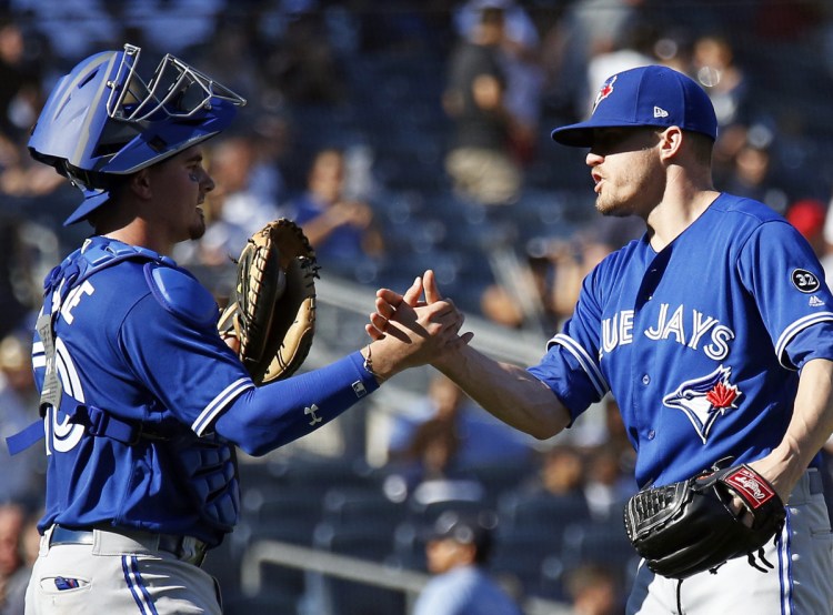 Blue Jays reliever Ken Giles celebrates with catcher Reese McGuire after Toronto's 3-2 come-from-behind win over the Yankees in New York on Sunday.