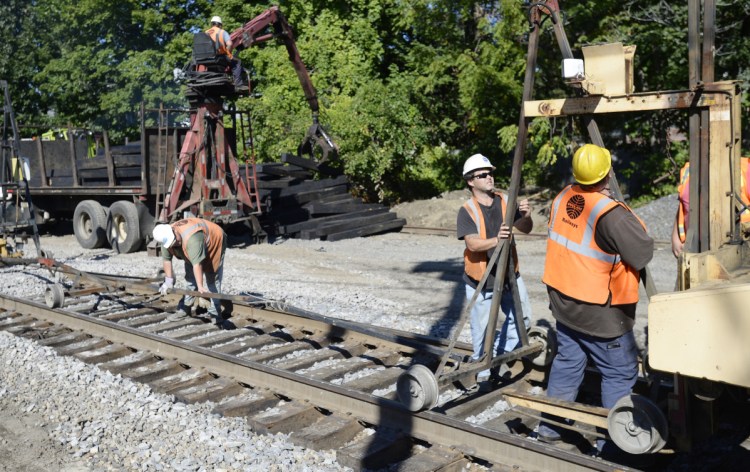 Crews work to replace rail ties along the Amtrak Downeaster line off Forest Avenue in Portland on Friday. The project is expected to be completed in October.
