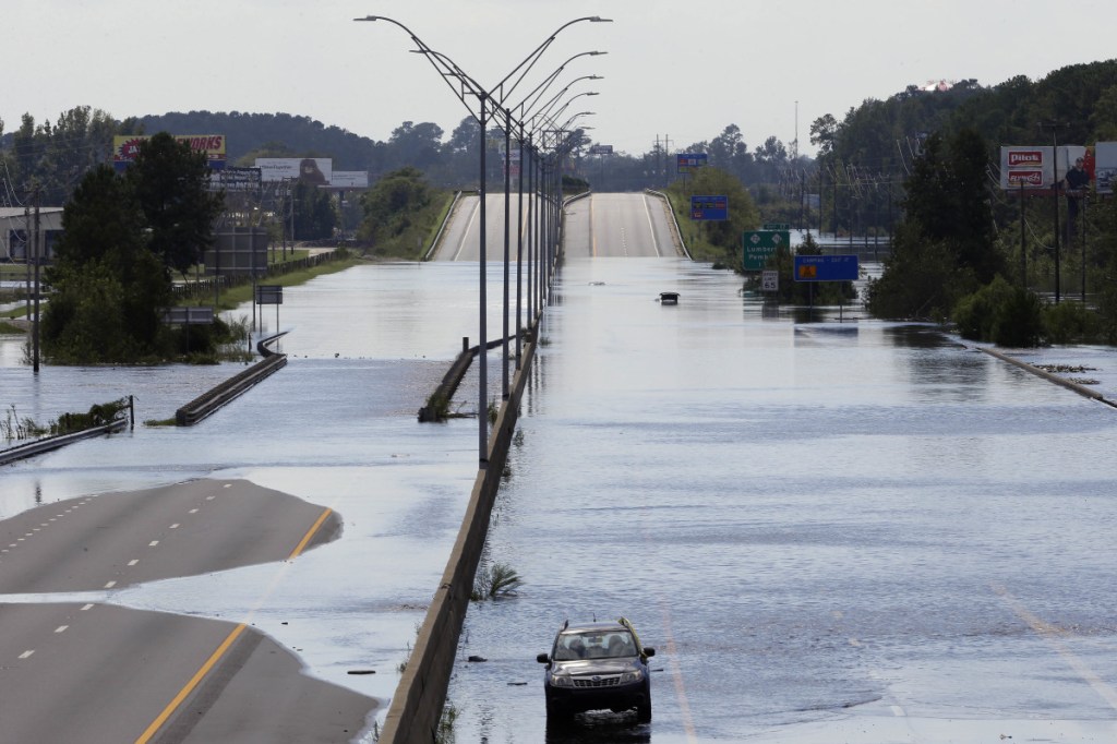 Flooded vehicles sit on a closed section of Interstate 95 in Lumberton, N.C., where the Lumber River overflowed following flooding from Hurricane Florence on Monday. Navigation apps like Waze are trying to help motorists avoid hurricane flooding, but local authorities say people shouldn't rely on them.
