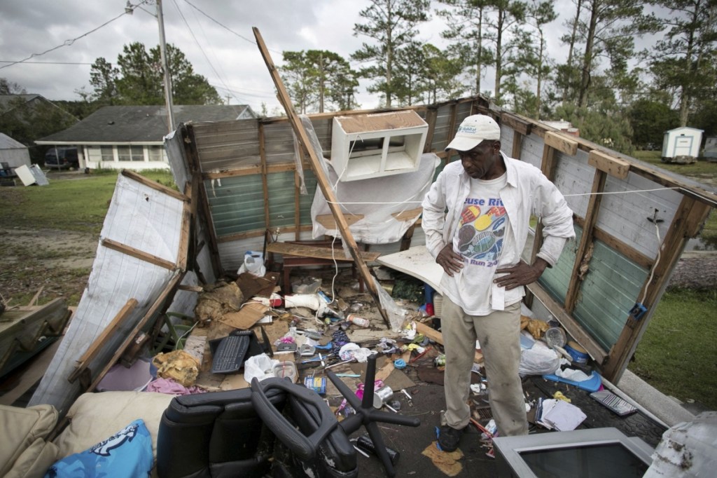 Tony Thompson checks the damage to his mobile home from Hurricane Florence on Sunday. FEMA grants are far lower than what it would cost to replace a home like his.