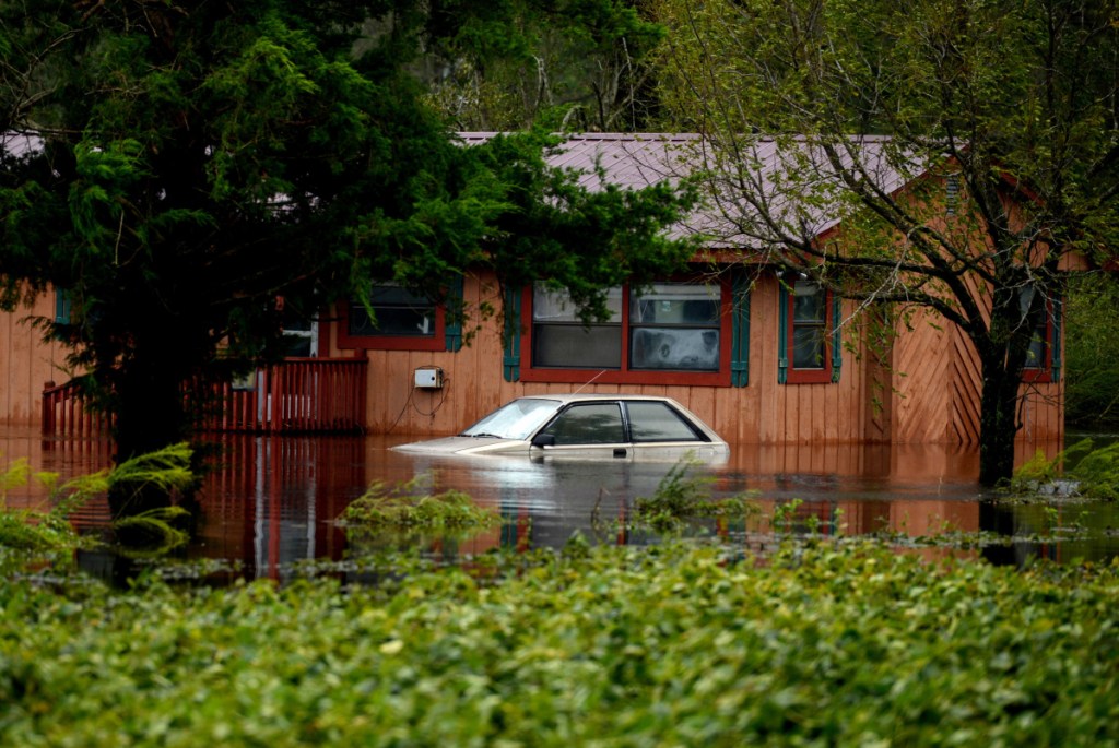 A car and home are partially submerged in floodwaters from Florence near Beulaville, North Carolina, on Sunday. Mold begins growing within 48 hours of water in a home, which can trigger allergies or asthma.