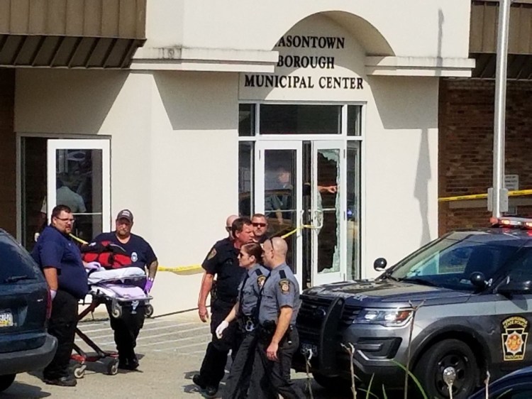 Law enforcement and emergency personnel gather outside the office of District Judge Daniel Shimshock's office in Masontown, Pa., on Wednesday. A gunman opened fire in the lobby, wounding four people before being shot dead by police.