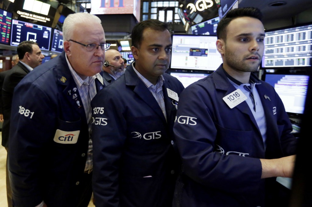 Trader Thomas Ferrigno, left, works with specialists Dilip Patel, center, and Karan Virdi on the floor of the New York Stock Exchange on Aug. 31.
