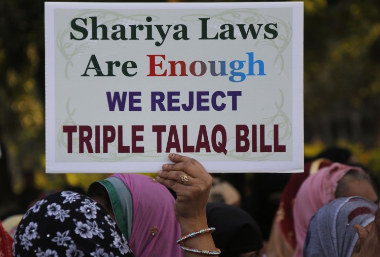 An Indian Muslim woman holds a placard during a protest against a new draft law aimed at banning the practice of instant divorce in Ahmadabad, India. 