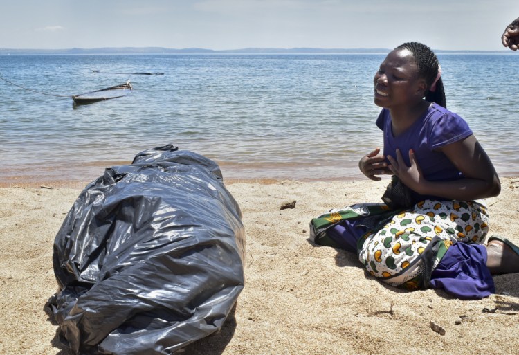 A woman cries beside the body of her sister, a victim of the MV Nyerere passenger ferry, as she awaits transportation for burial on Ukara Island, Tanzania, on Saturday. The death toll soared past 200 two days after the Lake Victoria disaster. 