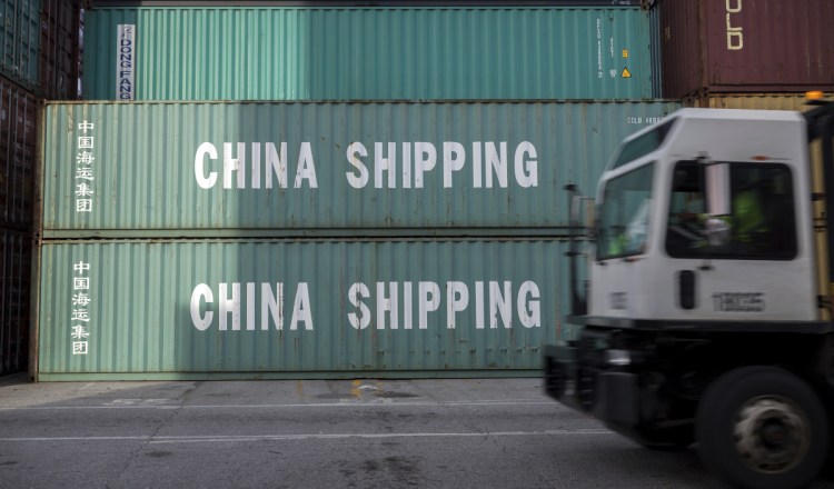 A truck passes a stack of 40-foot China shipping containers at the Port of Savannah in Georgia.