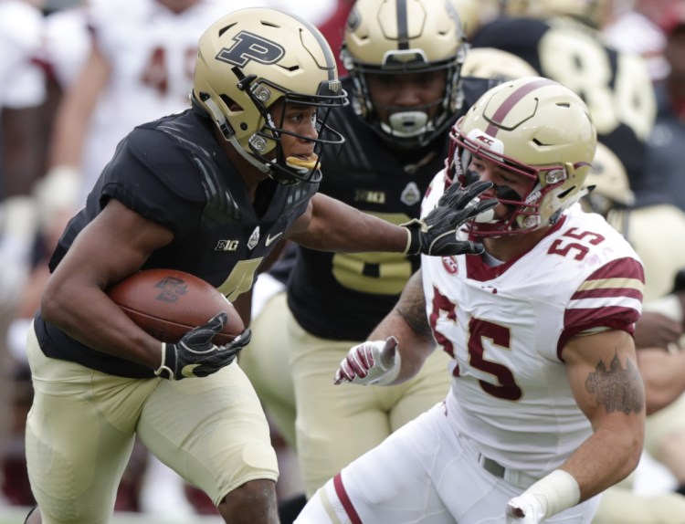 Rondale Moore of Purdue stiff-arms Boston College linebacker Isaiah McDuffie after making a catch Saturday during the first half of Purdue's 30-13 victory.