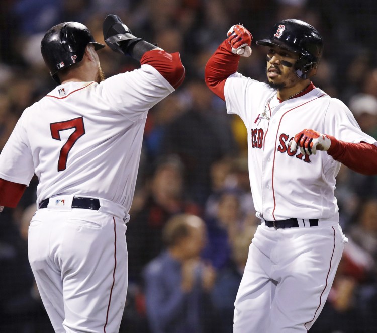 Boston's Mookie Betts, right, is congratulated by Christian Vazquez after Betts hit a two-run home run, his 32nd of the season, on Monday at Fenway Park in Boston.