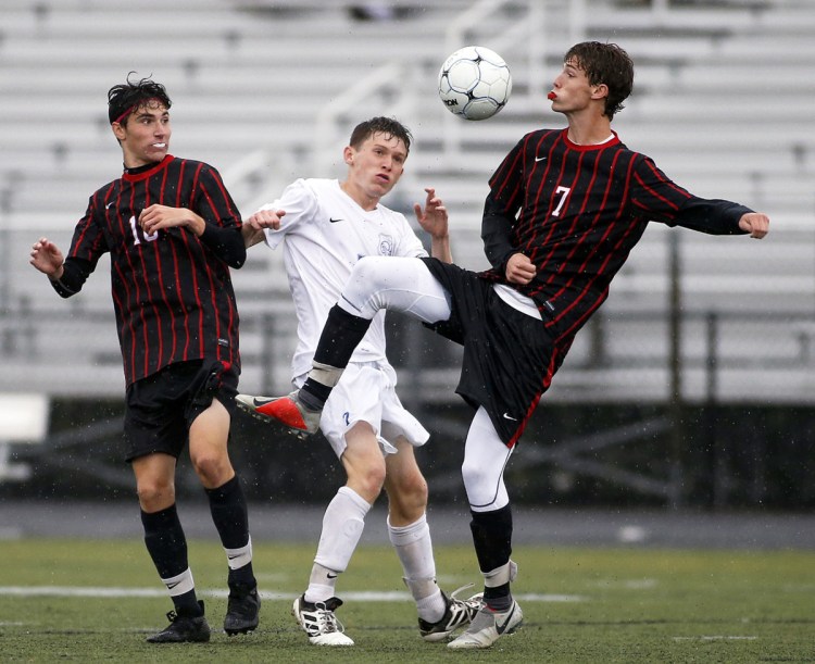Scarborough's Matthew Ricker, left, and Liam Bridgham vie with Kennebunk's James Rogers for the ball in Tuesday's boys' soccer game at Scarborough. The Red Storm won 1-0 to move up to fourth in the Class A South Heal point standings.