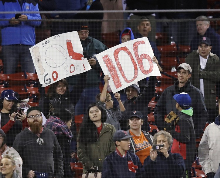 Boston Red Sox fans hold up a sign celebrating the team's franchise-record 106th win of the season Monday night against Baltimore. The number could end up as merely a footnote without a World Series championship.