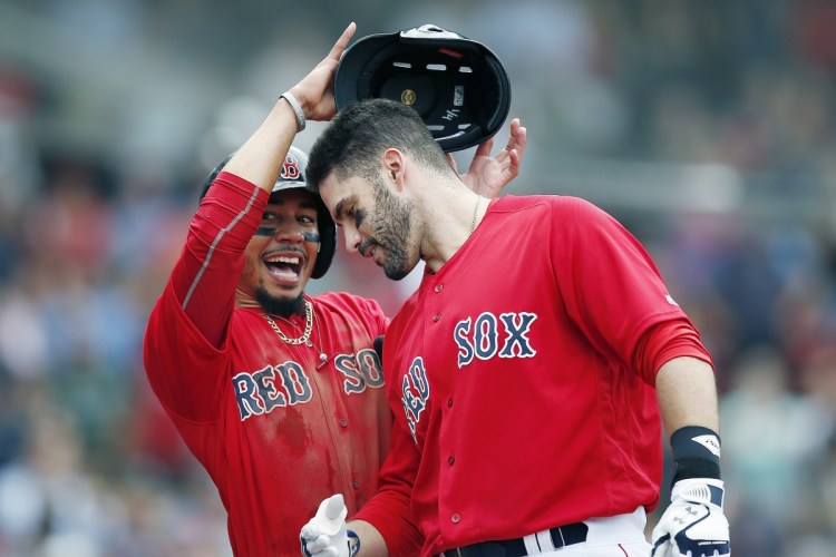 Boston's Mookie Betts, left, celebrates after scoring on a three-run home run by J.D. Martinez, right, during the first game of a  doubleheader against the Orioles on Wednesday in Boston.