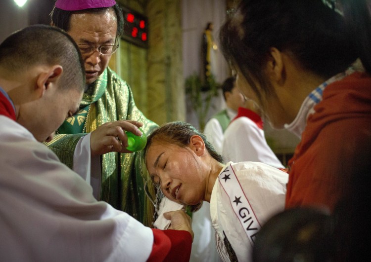 Chinese Bishop Joseph Li Shan performs a baptism Sept. 22 at the Cathedral of the Immaculate Conception, a government-sanctioned Catholic church in Beijing.