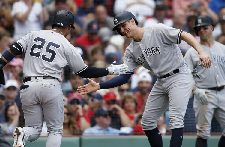 Gleyber Torres, is greeted at home plate by Greg Bird after hitting a two-run home run, the record-setting 265th of the season for the Yankees, during their 8-5 win over the Red Sox on Saturday in Boston.
