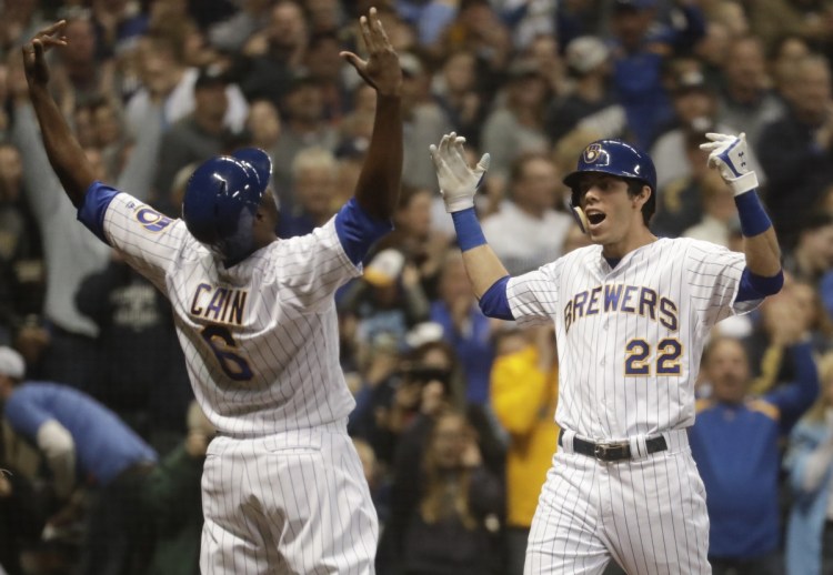 Milwaukee's Christian Yelich celebrates his two-run home run with Lorenzo Cain during the third inning against Detroit on Saturday in Milwaukee.