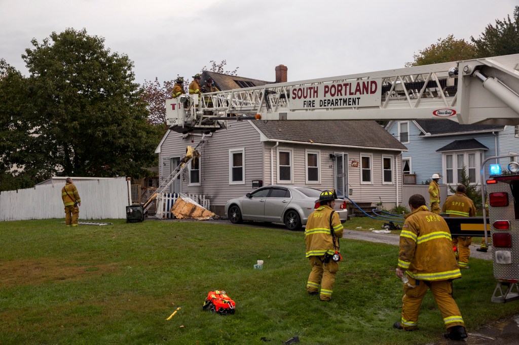 Firefighters finish putting out a fire in the second floor of a single family home at 12 Calais St. on Tuesday morning. South Portland Fire Chief James Wilson said the fire most likely started from an electrical problem, but they can't be certain until later. Both occupants of the home and their dogs were awake when the fire started and safely evacuated. 