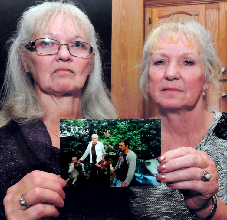 Joan Cuares, left, and Debbie Deyoung, hold a photograph that shows their brother Dana Kitchin on Dec. 18, 2014. Kitchin was found dead Dec. 12, 2014, at the Kennebec County Correctional Facility in Augusta. 