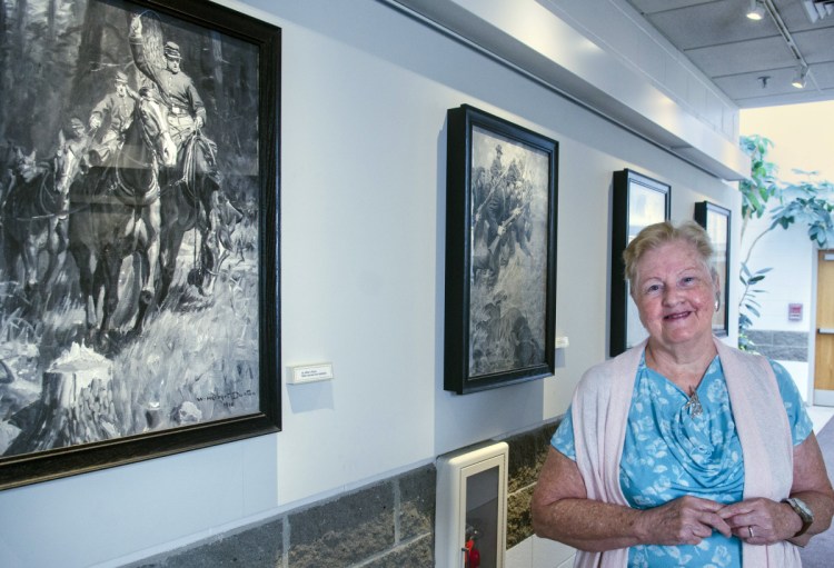 Mary Mayo-Wescott poses for a portrait with the seven paintings given to Augusta by accomplished artist and city native William Herbert "Buck" Dunton, depicting Civil War scenes on Aug. 31 at Augusta City Center. She was part of a city government committee that arranged to preserve and display them.