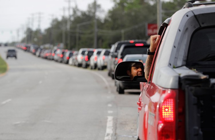 Motorists wait in a long line to buy gas at a station near Wilmington, N.C., on Monday. Floodwaters from Hurricane Florence cut off areas around Wilmington, forcing people to stand in long lines for fuel, food and other supplies. 
