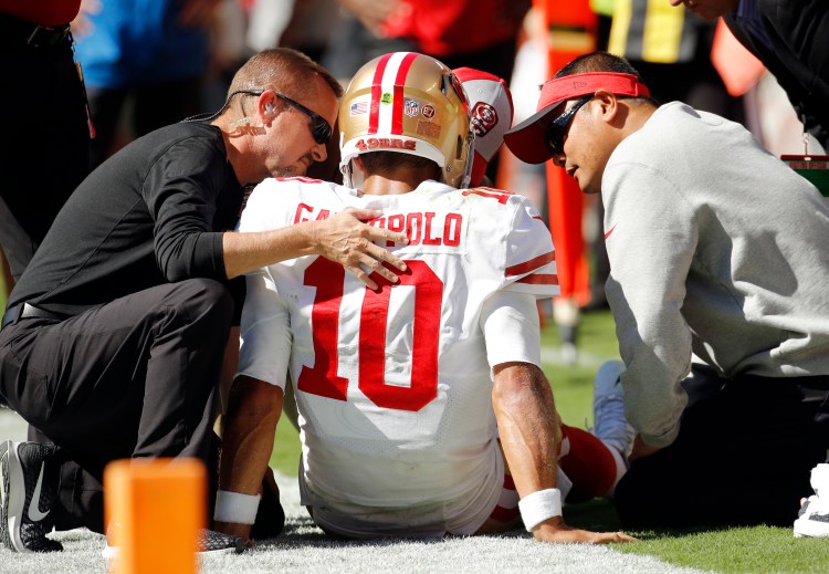 Trainers attend to San Francisco 49ers quarterback Jimmy Garoppolo who was injured after a tackle by Kansas City Chiefs defensive back Steven Nelson during the second half of their game Sunday in Kansas City, Mo.