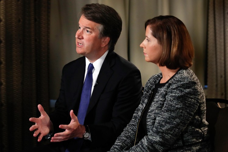 Brett Kavanaugh, with his wife, Ashley Estes Kavanaugh, answers questions during a Fox News interview Monday in Washington about allegations of sexual misconduct against the Supreme Court nominee. Kavanaugh accused his opponents of launching "smears, pure and simple."