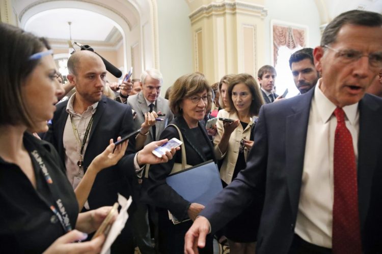 Sen. John Barrasso, R-Wyo., right, leads Sen. Susan Collins, R-Maine, followed by Sen. Rob Portman, R-Ohio, through a crowd of reporters after a Republican lunch meeting on Capitol Hill last week.