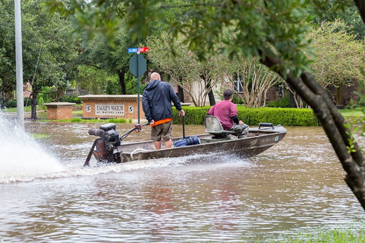 Cajun Navy volunteers from Austin ride a boat in a flooded street in Missouri City Texas after Hurricane Harvey in August 2017.