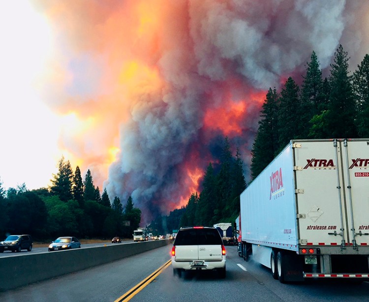 A fire rages as motorists travel on Interstate 5 near Lake Shasta, Calif. on Wednesday.